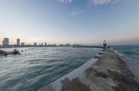 an expanse of water and sea with a cityscape in the distance with a building on one of them