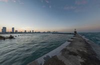 an expanse of water and sea with a cityscape in the distance with a building on one of them