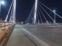 a view from a bridge across the city at night, looking down towards a city