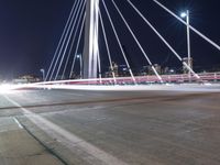 a view from a bridge across the city at night, looking down towards a city