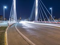 a view from a bridge across the city at night, looking down towards a city