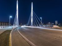 a view from a bridge across the city at night, looking down towards a city