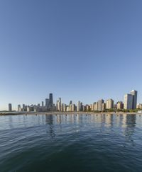 a city skyline reflected in the waters on a clear day in chicago, illinois / /