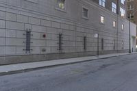 there is a stop sign in the street outside of a building, next to a street