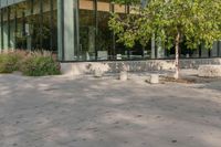 the child is playing on the skateboard in the plaza in front of the building