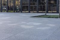 a small child is running in front of the glass buildings on the street as he rides a skateboard