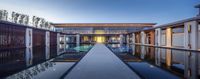 there is a long rectangular reflection in the water on this beautiful house - like pool