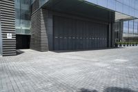 a couple walking out of the large, modern building with double doors and garage door on the outside