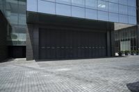a couple walking out of the large, modern building with double doors and garage door on the outside