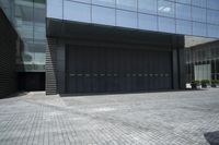a couple walking out of the large, modern building with double doors and garage door on the outside