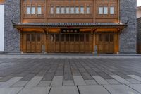 the door is open on the outside of a building in china with carved wood doors and brick flooring