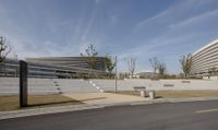 several buildings are on the edge of the road near a road and concrete wall that has a curved shape