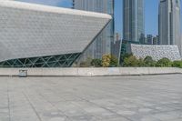 a young man skateboarding across an open area near the city buildings in the background