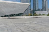 a young man skateboarding across an open area near the city buildings in the background