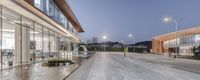 a courtyard with a large pond, wooden flooring and high tech glass walls, at night