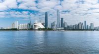 the city skyline is filled with skyscrapers by the water and a ferryboat is going in the distance