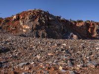 a lone sheep standing in the rocky terrain of a rocky outcropping area