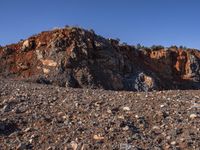 a lone sheep standing in the rocky terrain of a rocky outcropping area