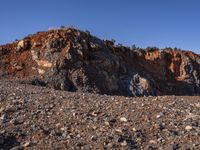 a lone sheep standing in the rocky terrain of a rocky outcropping area