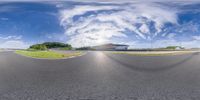 a large mirror of a track that is wide open to the outdoors with some clouds