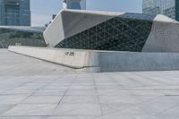 two people walk together in front of a large building that has a geometric design on the front of it