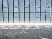 an empty parking garage with lots of windows and bricks on the ground of it,