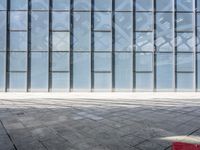 an empty parking garage with lots of windows and bricks on the ground of it,
