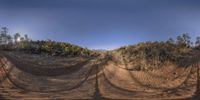 a very pretty dirt road with a big dirt hill in the background as if at the top