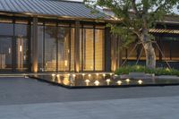 modern outdoor lighting set up at a building by a fountain outside at night time and tree outside