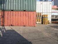 a cat sitting in a room next to some shipping containers and buildings on the street