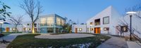 the courtyard and outside space are visible at night as well as the surrounding buildings are lit up with lamps