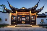 a white building with a wooden entrance and two windows at dusk in wutai china