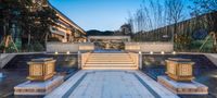 an outdoor patio with steps leading up to trees and water features at the bottom of a large waterfall