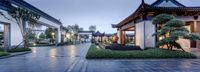 the walkway at the spa is lined with green plants and trees in the rain - soaked courtyard