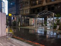 an outside restaurant on a rainy day with a neon sign, lights and benches in the rain