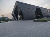 the building that is designed to be as black as possible in a city, looks like it's leaning on a face