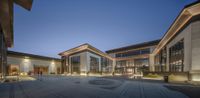 the large building has several courtyard areas lit up with light fixtures at night time time