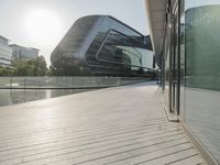 a walkway with many buildings by the water on it next to a building with many windows