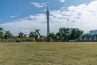 a man is holding up a kite in the park near the television tower in tokyo