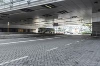 a street with parking spaces and white bricks in the floor near by a large building