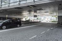 a street with parking spaces and white bricks in the floor near by a large building