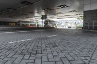 a street with parking spaces and white bricks in the floor near by a large building