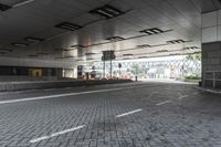 a street with parking spaces and white bricks in the floor near by a large building