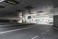 a street with parking spaces and white bricks in the floor near by a large building