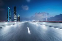 an asphalt road in the city with the skyline of moscow at night sky and cars