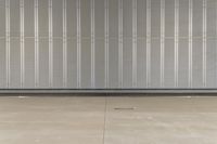 a man is standing inside an industrial garage door with his skateboard on his hand