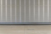 a man is standing inside an industrial garage door with his skateboard on his hand