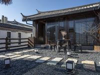 a porch with a lot of tables and chairs in it next to a building with a small courtyard area