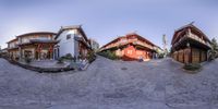 the fisheye photo is taken from two different angles, including houses and a stone road