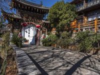 a building with several chinese archways above the gate that leads up to it and a stream below